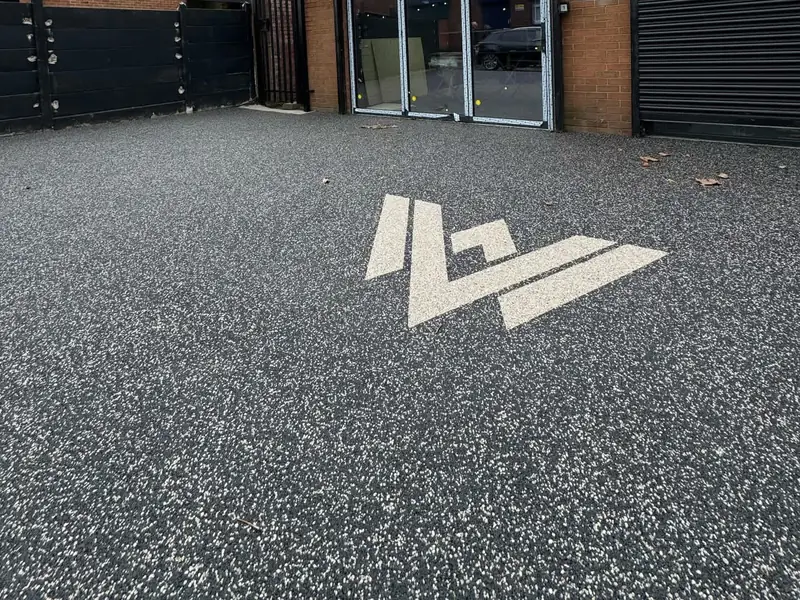Dark resin bound forecourt with a white Wolfsburg Vans logo inlay