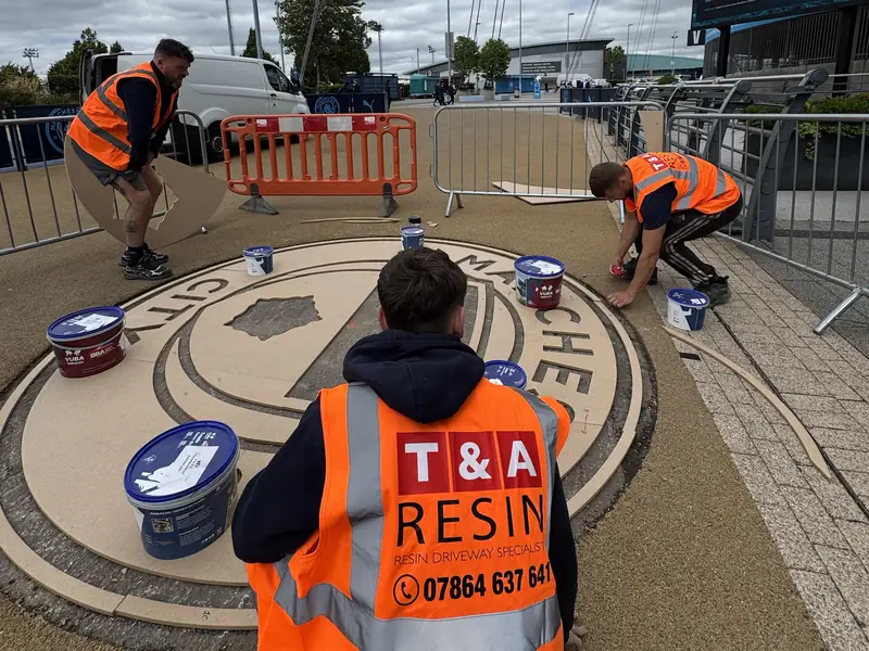 T&A Resin team in branded hi vis laying the Manchester City crest at the Etihad Stadium