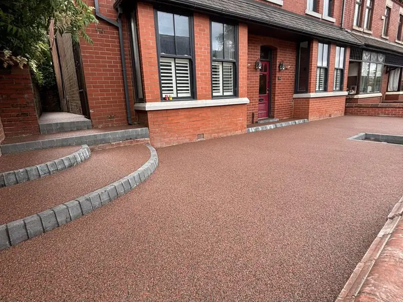 Red resin bound driveway with curved block edged steps outside a Victorian terrace